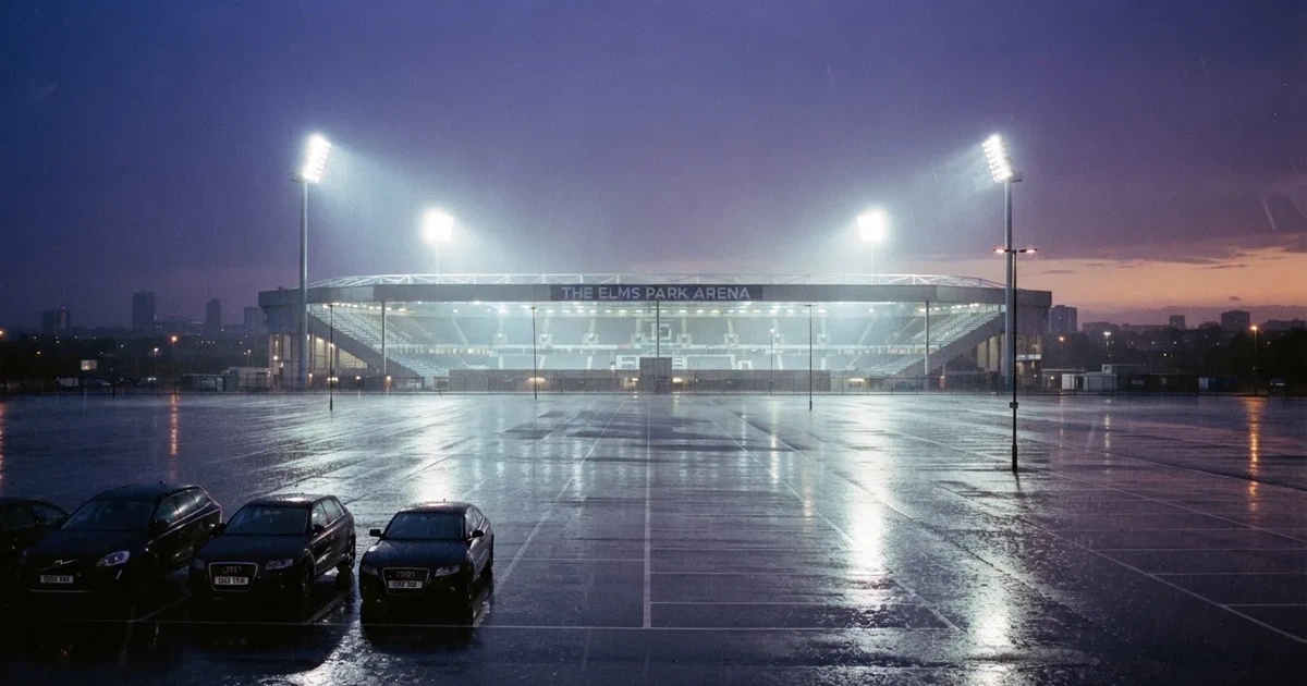 Ein Stadion unter Flutlicht aus großer Entfernung gesehen, davor ein regennasser Parkplatz in der Dämmerung.